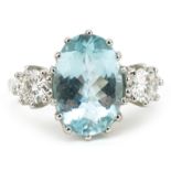 Unmarked white gold aquamarine and diamond three stone ring, tests as 18ct gold, total diamond