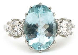 Unmarked white gold aquamarine and diamond three stone ring, tests as 18ct gold, total diamond