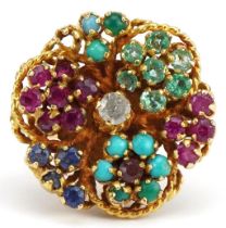 Continental gold multi gem cocktail ring set with a central diamond, rubies, emeralds, sapphires and