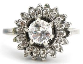 Unmarked white gold diamond three tier cluster ring, the central diamond approximately 0.65 carat,