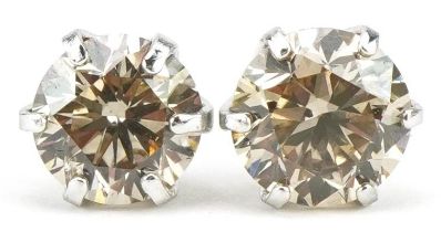 Pair of platinum round brilliant cut diamond solitaire stud earrings, total diamond weight