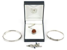 Silver jewellery comprising amber pendant on chain, sapphire brooch, christening bracelet and hinged