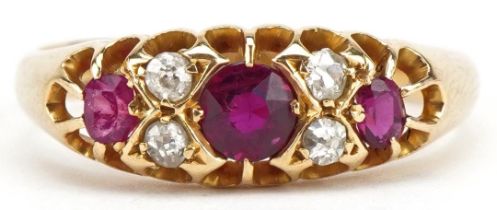 George V 18ct gold ruby and diamond seven stone ring with pierced setting, the central ruby