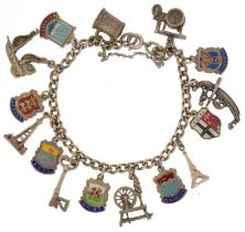 Silver charm bracelet with a large selection of mostly silver charms including enamelled souvenir