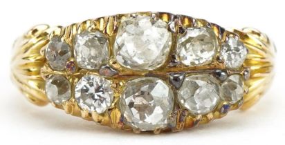 Antique 18ct gold diamond ten stone cluster ring with scrolled shoulders, the largest diamond