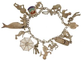 Silver charm bracelet with a selection of mostly silver charms including circus elephant, cricketer,