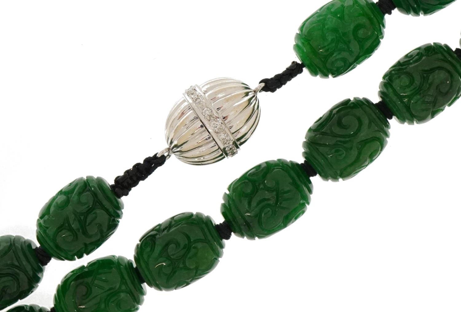 Chinese carved green jade bead necklace with 14ct white gold diamond set clasp, each bead 13.5mm x