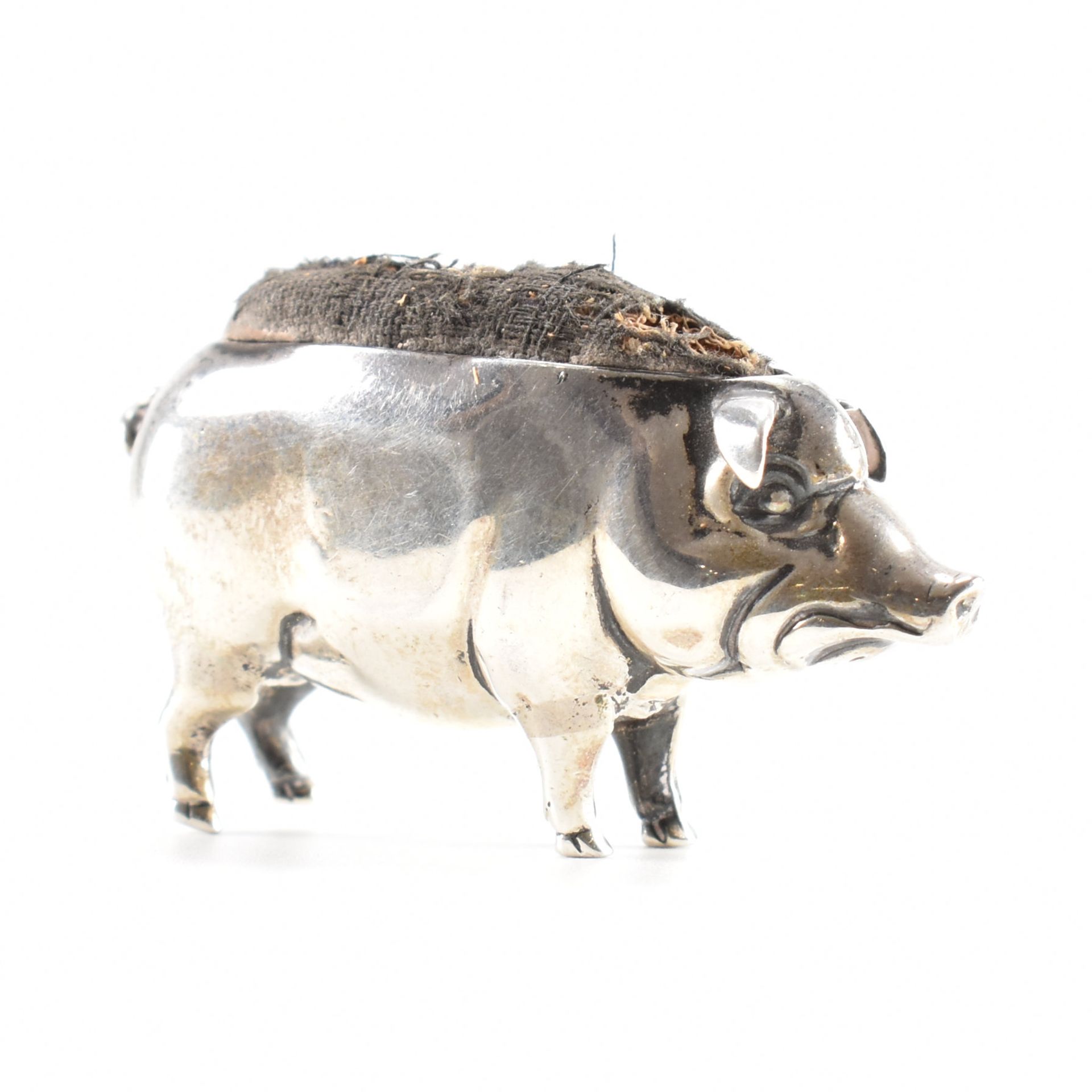 AN EDWARDIAN SILVER PIG PIN CUSHION