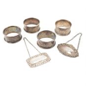 FOUR EDWARDIAN SILVER NAPKIN RINGS & 2 DECANTER LABELS