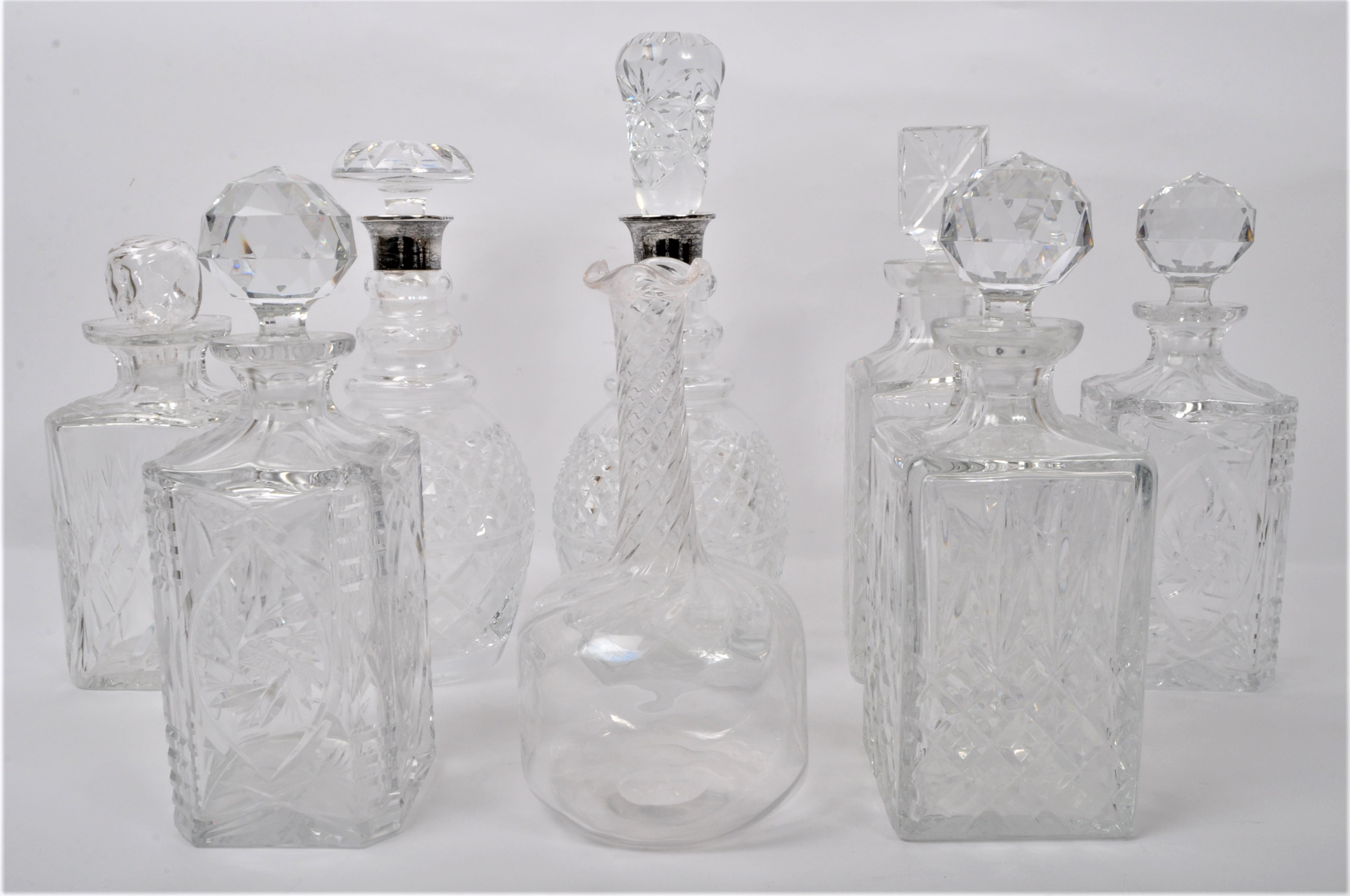EIGHT LARGE VINTAGE CUT GLASS DECANTERS