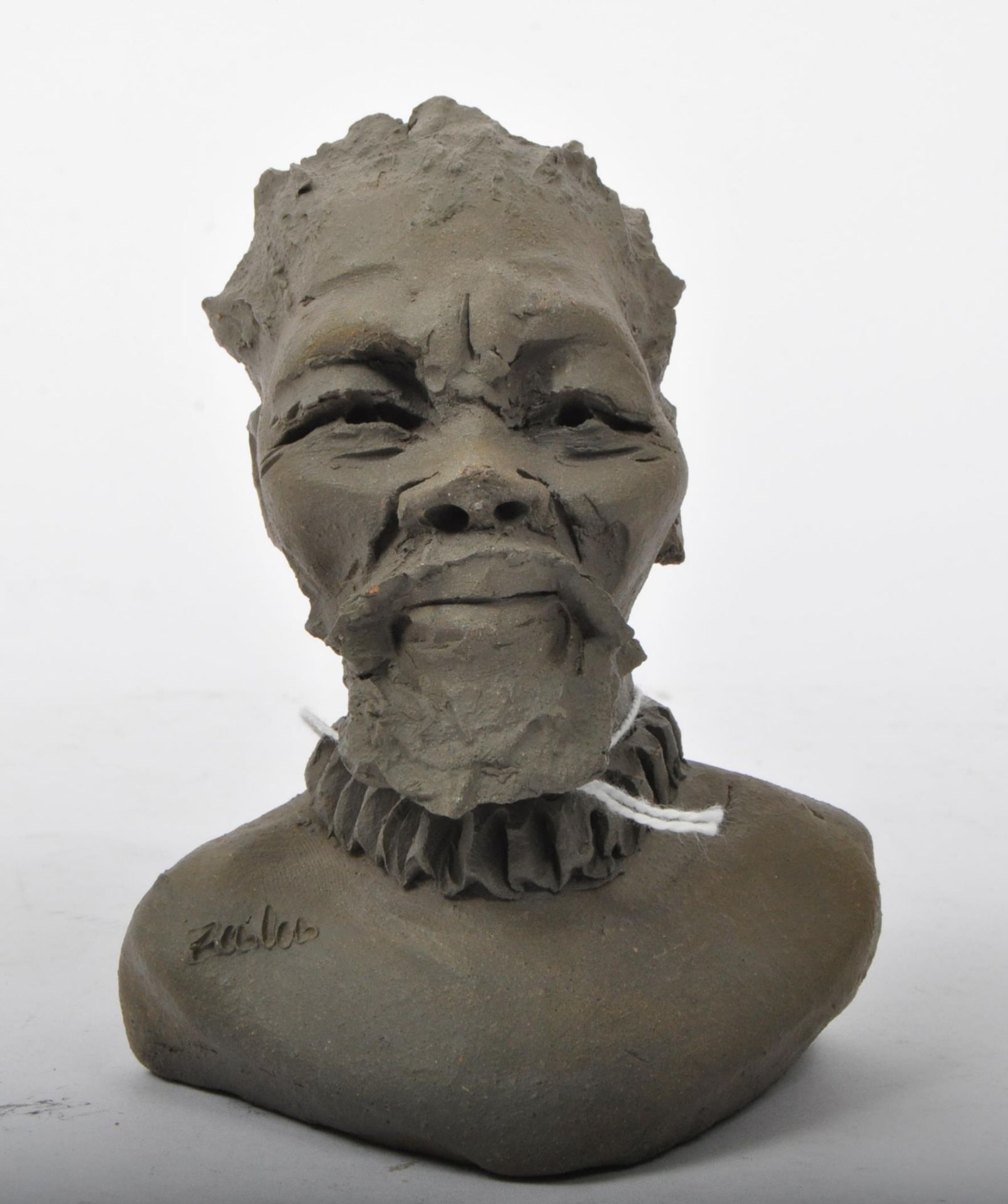 AN EARLY 20TH CENTURY CLAY POTTERY BUST OF A ZULU MAN