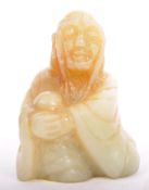 A SMALL CARVED CHINESE ORIENTAL GREEN JADE SITTING FIGURINE