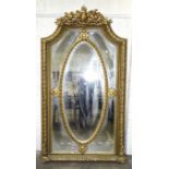 A large and impressive 20th century gilt gesso and wood mirror, the shaped top decorated with fruit,