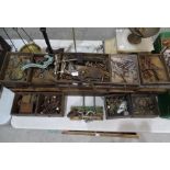 A collection of antique locks, fittings, large brass screws and miscellaneous items, within a