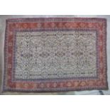 A mid-20th century Persian rug, the camel centre profusely decorated with flowers and foliage,