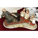 A Capodimonte music box sculpture 'The Boys Choir', depicting a music teacher at his piano and three