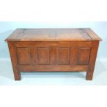 An antique oak panelled coffer, the lift lid above plain fielded panels and stiles extended to