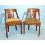 A pair of French Empire gilt metal-mounted side chairs, each with carved back, downswept arms with