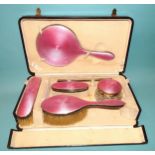 A silver and pink guilloche enamel-decorated five-piece dressing table set, comprising: hand mirror,