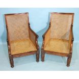 A pair of early-19th century mahogany Bergère caned deep-seated armchairs with scrolling arms, on