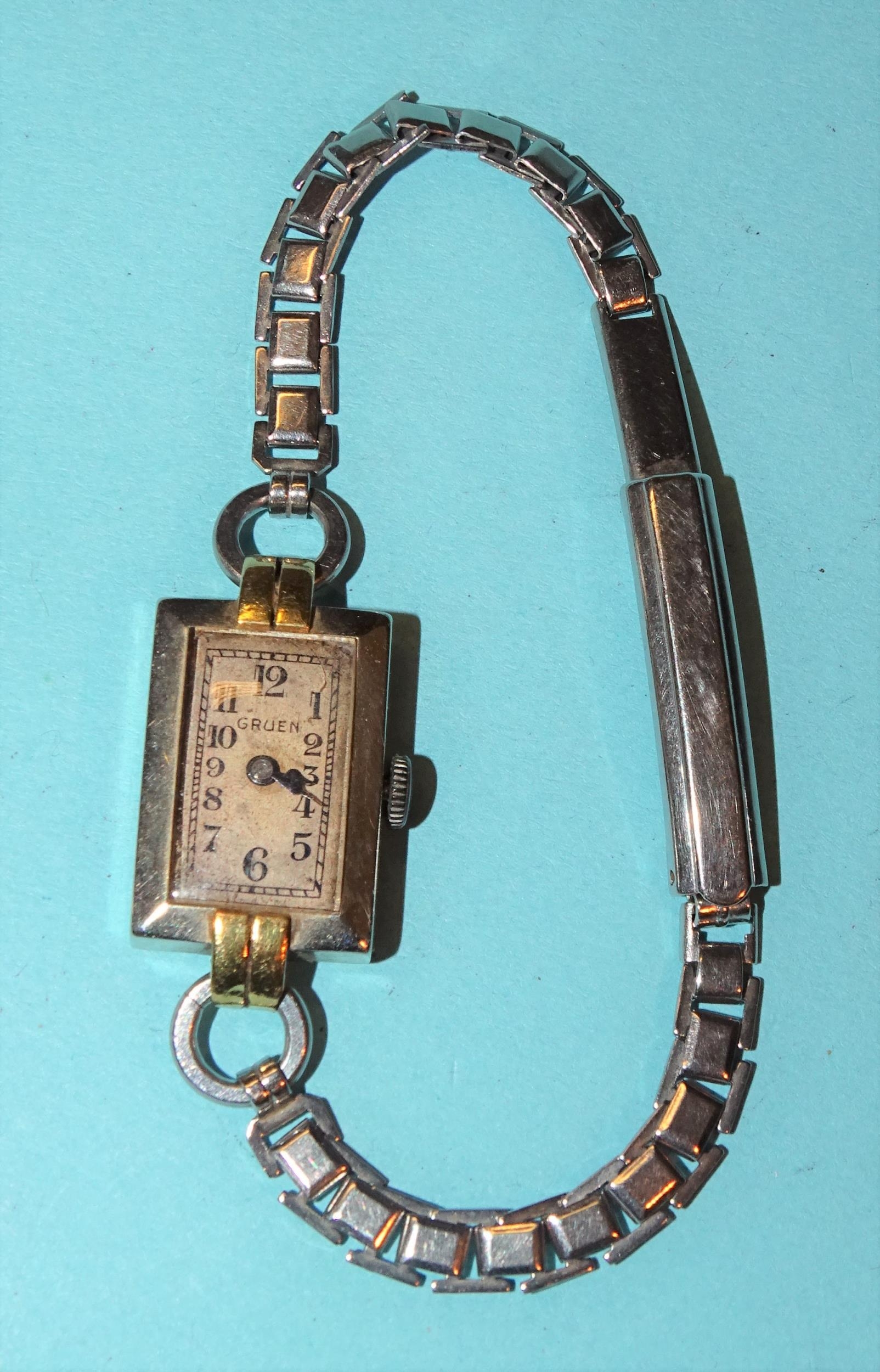 Gruen, a ladies' 18k white and yellow gold rectangular-cased wrist watch on white metal bracelet,