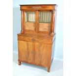 A 19th century French Empire-style side cabinet, having a pair of glazed doors enclosing an