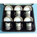 A set of six Royal Worcester coffee cans and saucers in pierced silver cup holders decorated with