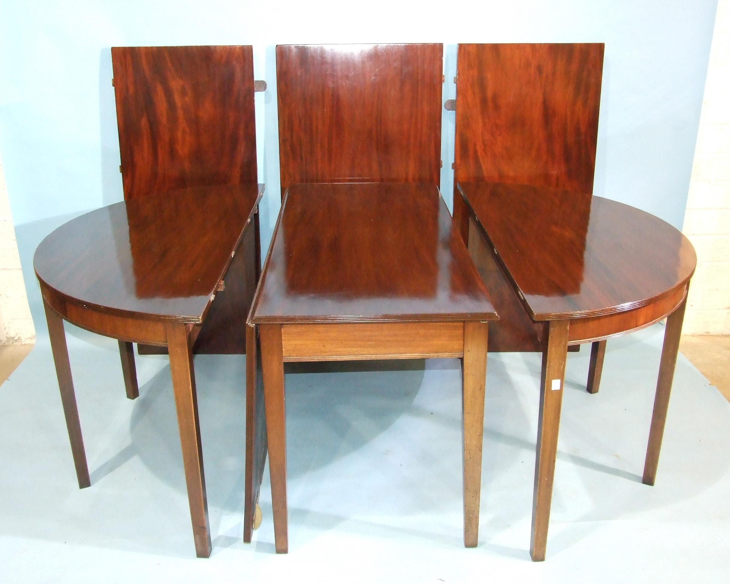 A large Georgian mahogany dining table, comprising two D-ends and drop-leaf centre section, together