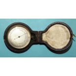 A brass-cased pocket barometer with silvered dial, (no maker's name), 4.5cm diameter, in leather