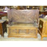 An early-20th century carved oak monks' bench, 114cm wide.