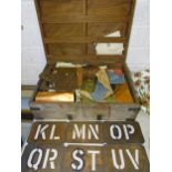 A collection of copper and metal letter and number stencil plates in wooden box.