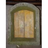 A stone window opening with arched top, 70cm high, 53cm wide.