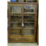 A 20th century oak two-door glazed bookcase, fitted with a base drawer, 102cm wide, 144cm high and a