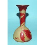 A small cameo glass bud vase in mustard yellow opaque glass, with red overlay etched leaf and