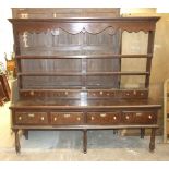 An 18th century oak dresser, the plate rack with cornice, shaped apron, three shelves and three