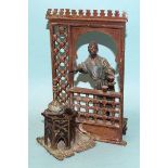 A similar cold-painted bronze group depicting a coffee seller in his stall, the inkstand with hinged