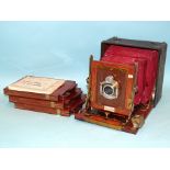 A Junior Sanderson mahogany and brass plate camera with Beck Symmetrical lens, red leather