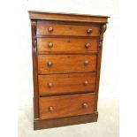 An early-19th century Wellington-style chest of five graduated drawers, within carved corbels, on