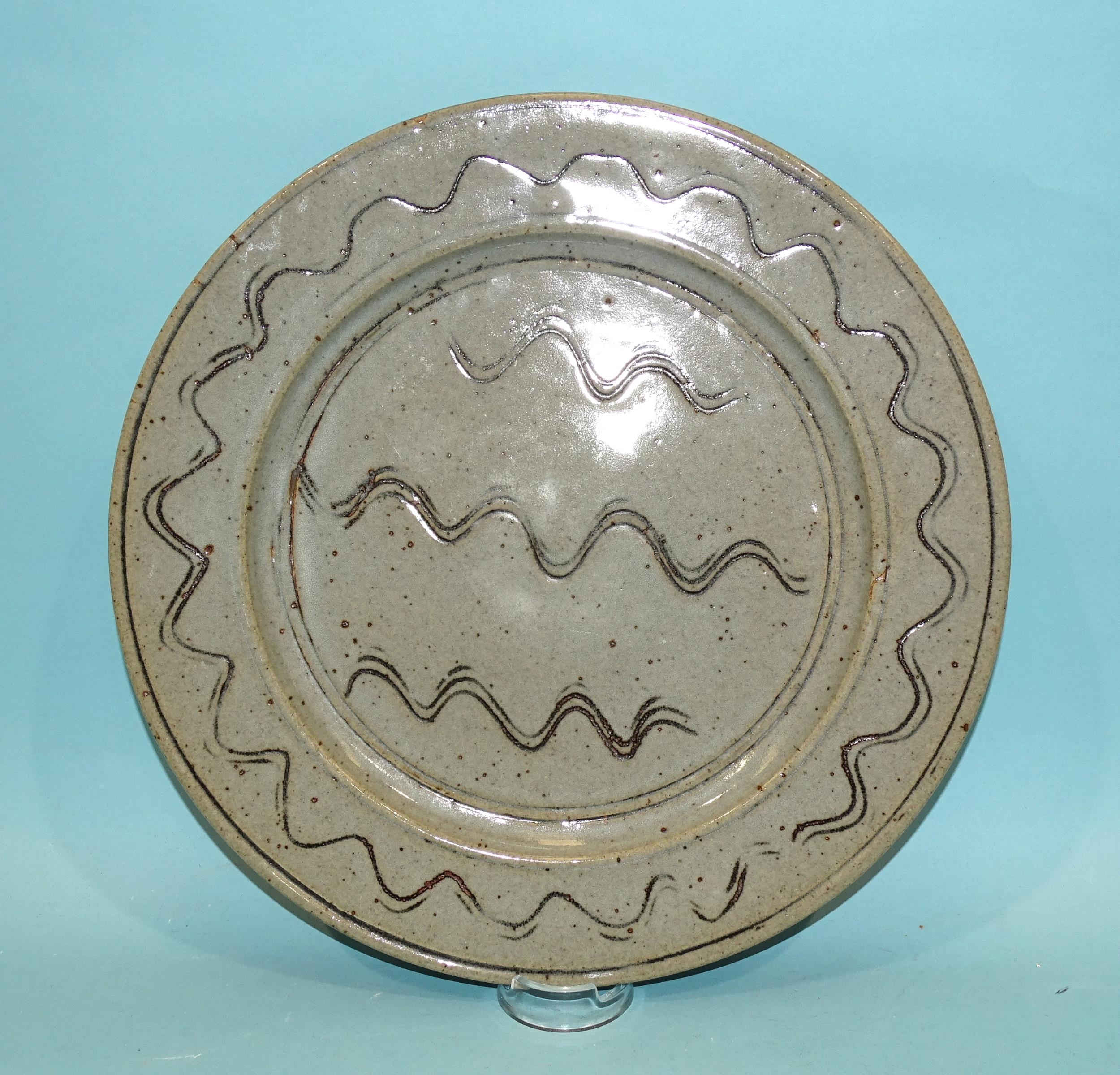 Ray Finch, Winchcombe Pottery, a circular glazed charger decorated with incised wavy lines, 32cm dia