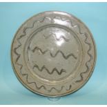 Ray Finch, Winchcombe Pottery, a circular glazed charger decorated with incised wavy lines, 32cm dia