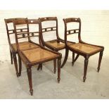 A set of four early-19th century stained beech dining chairs, each open back and caned seat on