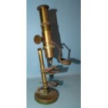 An early-20th century brass monocular microscope.