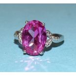 A white gold ring claw-set a pink sapphire of approximately 6cts between diamond point-set