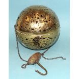 An Eastern brass incense ball of hinged spherical form, pierced and engraved with flowers, foliate