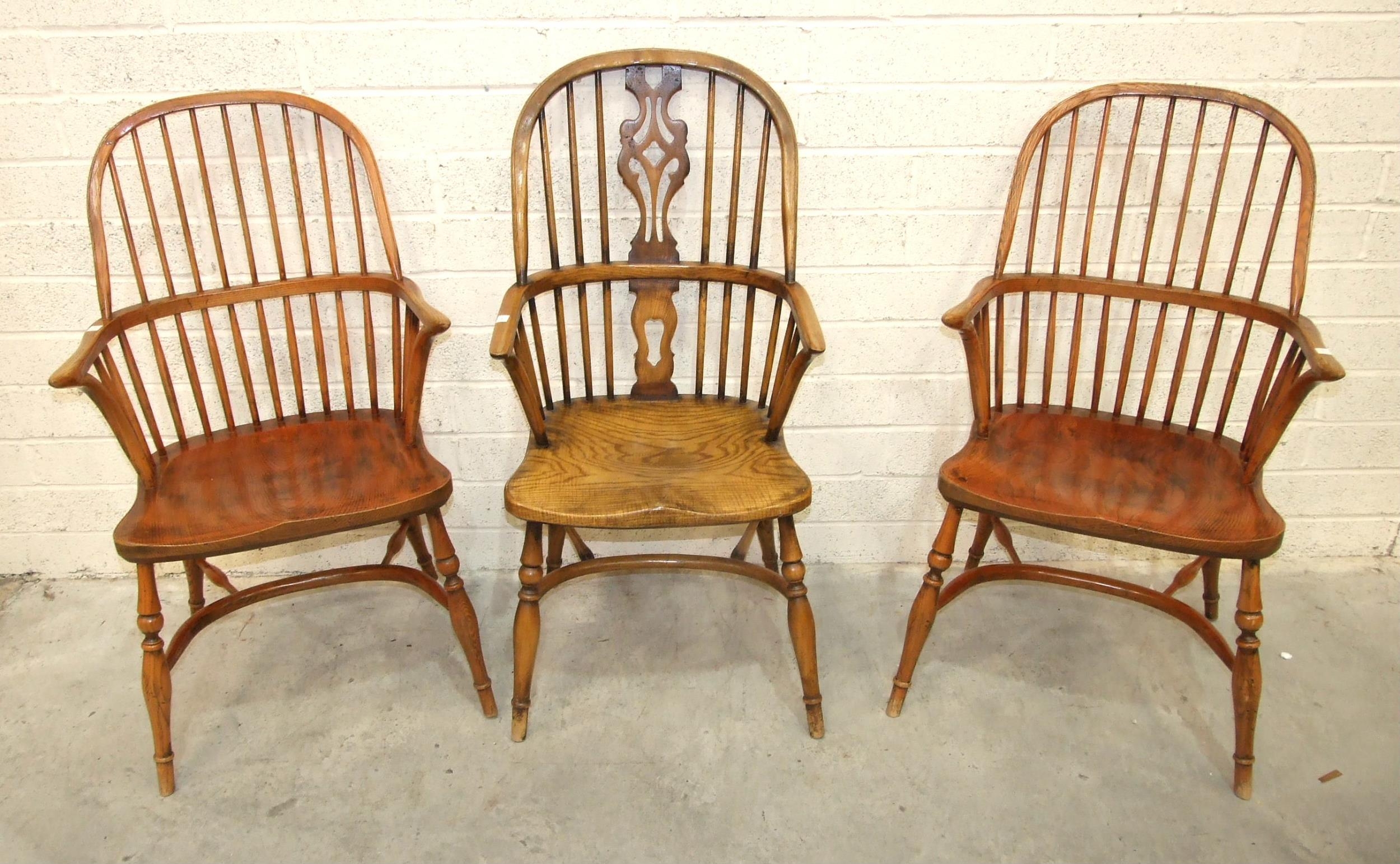 A pair of elm and beech comb-back Windsor chairs with crinoline stretchers and turned legs, (reddish