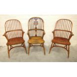 A pair of elm and beech comb-back Windsor chairs with crinoline stretchers and turned legs, (reddish