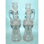 A pair of cut-glass and etched thistle-shaped decanters and stoppers, the stoppers with tot finials,