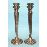 A pair of silver candlesticks of tapering form, on loaded circular bases, 25cm high, (marks rubbed),