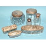 A collection of six glass silver-lidded dressing table boxes and containers, including two