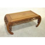 A Chinese low hardwood rectangular-shaped table with decorated carved frieze and curved supports,